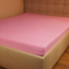 Prześcieradło jersey z gumką jasno różowe na łóżku firmy TuliSen.