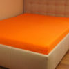 Prześcieradło jesrey z gumką pomarańczowe na łóżku firmy TuliSen.