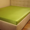 Prześcieradło satyna bawełniana z gumką zielone na łóżku firmy TuliSen.